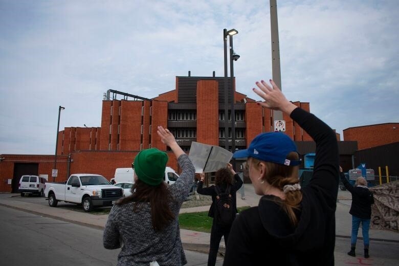 People waving at a prison.